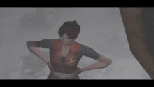 a woman in a red vest is standing in the snow with her hands on her hips