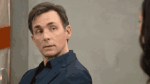a man in a suit is looking at a woman