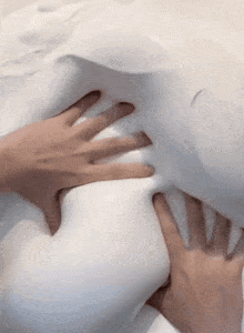 a person 's hands are pressing against a white object