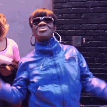 a woman wearing sunglasses and a blue jacket