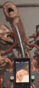 a person is taking a picture of a statue with a cell phone