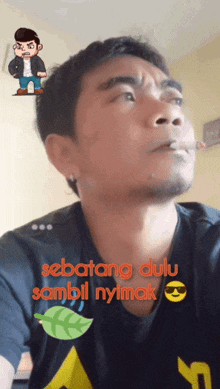 a man in a black shirt with the words sebatang dulu sambil nyimak written on it
