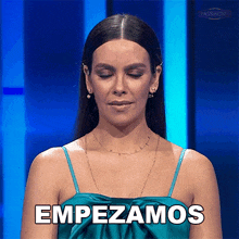 a woman in a blue dress says " empezamos "