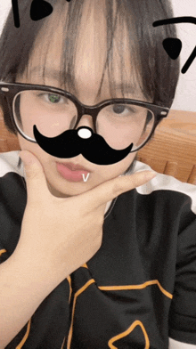 a girl wearing glasses and a fake mustache is making a funny face