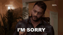 a man is saying i 'm sorry in front of a bet logo