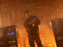 a man holding a gun in a room with a few servers that say ' a ' on the front