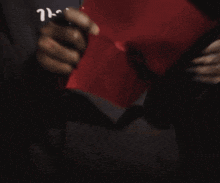 a person holds a piece of red paper in their hand