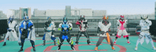 a group of superheros are standing in a line on a roof