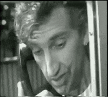 a man is talking on a cell phone in a black and white photo .