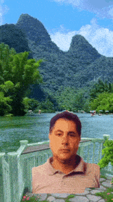 a man is standing in front of a lake and mountains