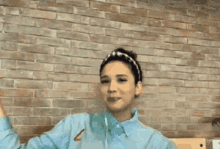 a woman wearing a headband is smiling with her hands folded