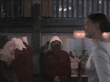 a group of nuns are standing in a room with a man in the background