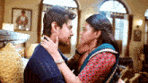 a man and a woman are kissing in a room