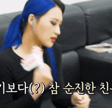 a woman with blue hair is sitting on a couch with korean writing on it