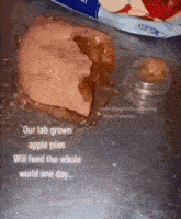 a piece of apple pie is sitting on a table next to a plastic container