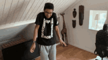 a young man wearing a black t-shirt that says the future is now