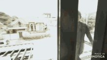 a man is standing in front of a window with the words made in animatica below him