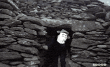 a black and white photo of a man in a stone building