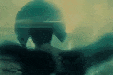 a blurry picture of a person wearing a helmet in a dark room