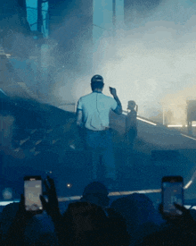 a man in a white shirt is standing on a stage with a microphone