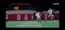 a football game is being played in front of a sign that says dakota