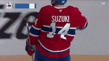 a hockey player named suzuki wears a red white and blue jersey
