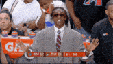 a man in a suit and tie is watching a basketball game