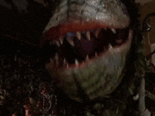 a close up of a plant monster with its mouth open and the words `` shit sherlock '' written on it .