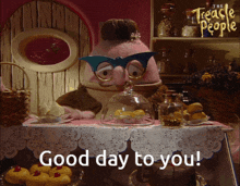a cartoon character says good day to you in front of a table full of food