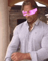 a man wearing a striped shirt and pink glasses .