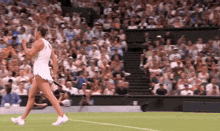 a tennis player is walking on the court with her racket in her hand