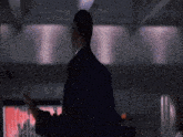 a man in a suit stands in front of a screen that shows a graph