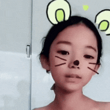 a young girl wearing a cat mask with ears on her head .