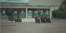 two scooters are parked in front of a minimart