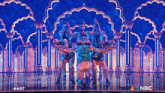 a group of people are dancing on a stage with a nbc logo in the corner