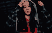 a woman in a red shirt and fishnet stockings is dancing in the dark