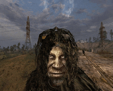 a man with dreadlocks is standing in a field with a sign that says ' danger ' on it