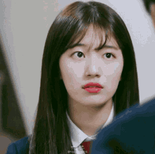a close up of a woman 's face with a man behind her looking at her