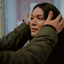 a man is putting his hands on a woman 's forehead