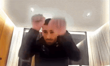 a man in a black jacket is making a funny face