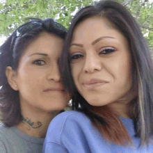 two women are posing for a picture and one has a tattoo on her neck that says ' ariel '