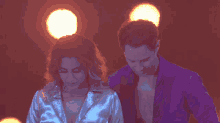 a man and a woman are dancing together in a dark room
