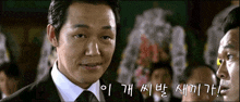 a man in a suit and tie is talking to another man in korean