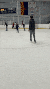 people are ice skating in front of a sign that says 2pm