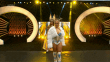 a woman in a fur coat is walking down a stage