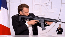 a man in a suit is holding a gun with the letter r on it