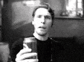 a man in a black shirt is holding a can of diet coke