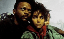 a man and a woman are standing next to each other and looking at the camera .