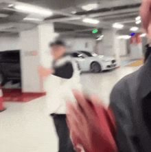 a blurry photo of people walking in a parking garage with a car in the background