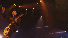 a man playing a guitar in front of a large screen that says ' sd ' on it